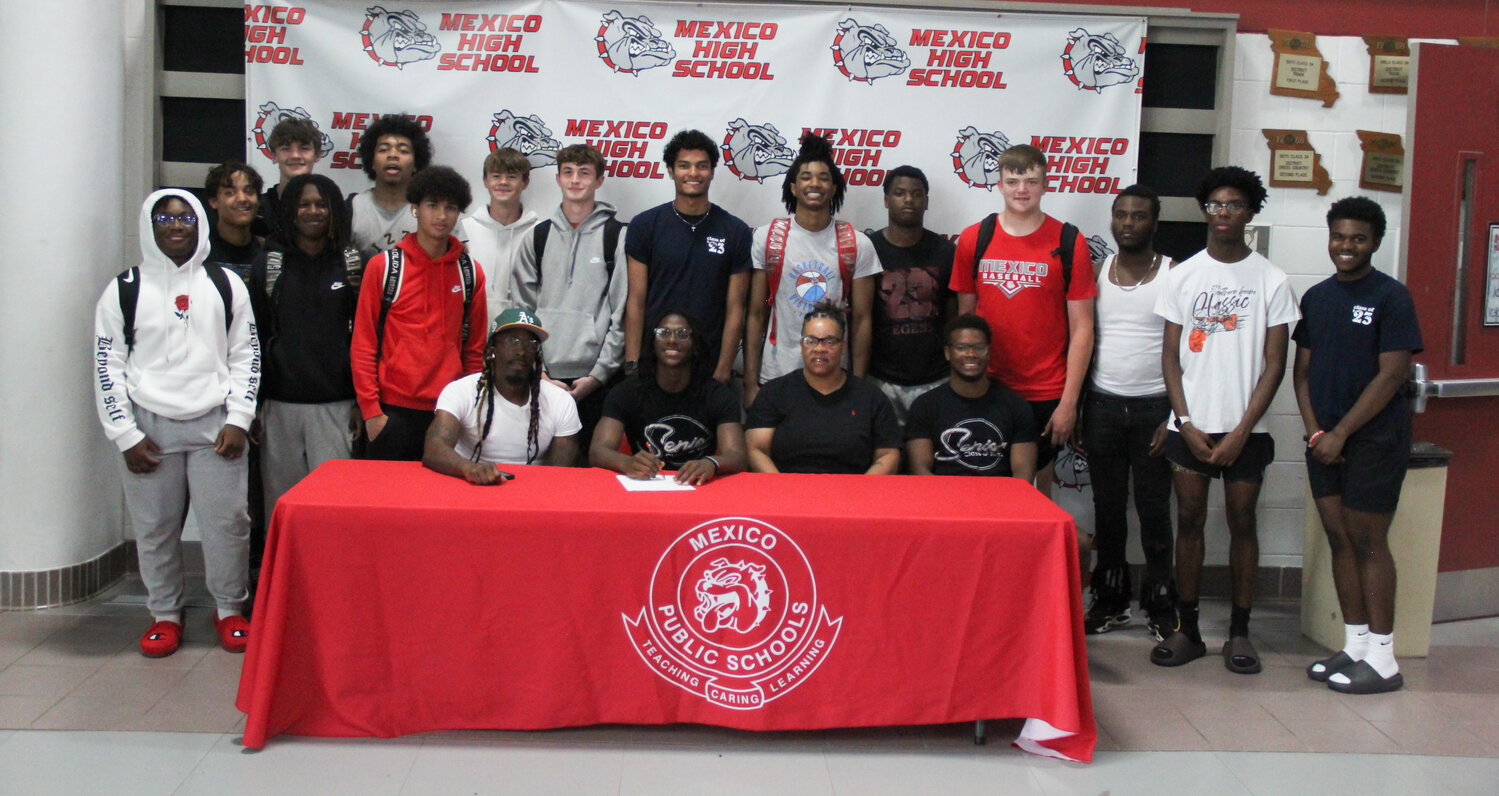 Mexico senior Jordan Shelton is surrounded by his family -- his father Jordan Shelton III, his mother Turkessa Nunnelly and half brother and teammate Anthony Shivers -- and the rest of his basketball teammates on Thursday at the Mexico Sports Complex. Shelton signed to play basketball for John Wood Community College in Quincy after two all-conference and all-district years for the Bulldogs.
