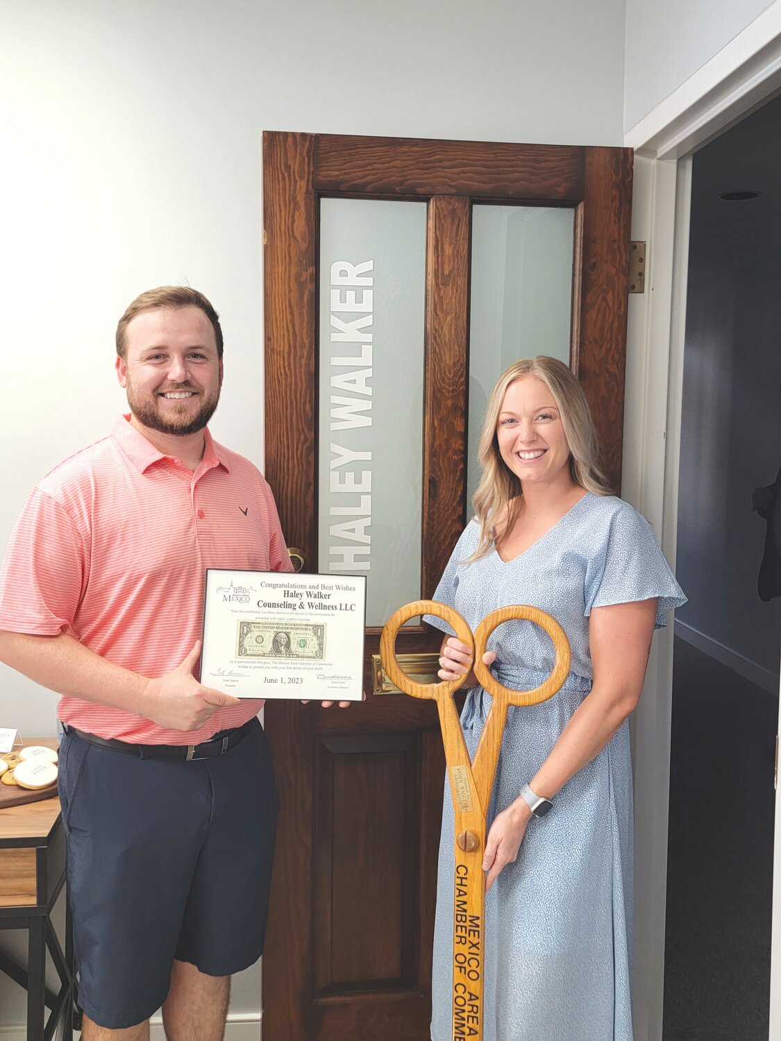 Logan Ray of Slumberland Furniture presented Haley Walker with her first dollar in front of her office on Thursday, June 1.