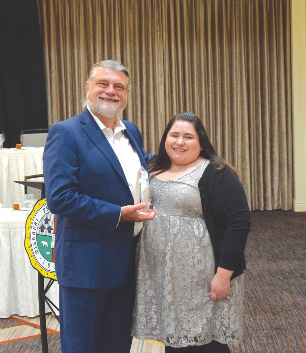 Laura White, daughter of Jane See White, accepted an award from the Missouri Press Association after her mother was inducted into the Missouri Press Hall of Fame.