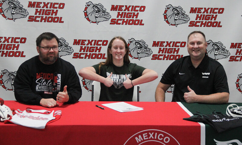 Mexico senior Katie Bowen sits with Mexico head coach Tony Senor (left) and William Woods head coach Jacob Lorentz during her signing ceremony.