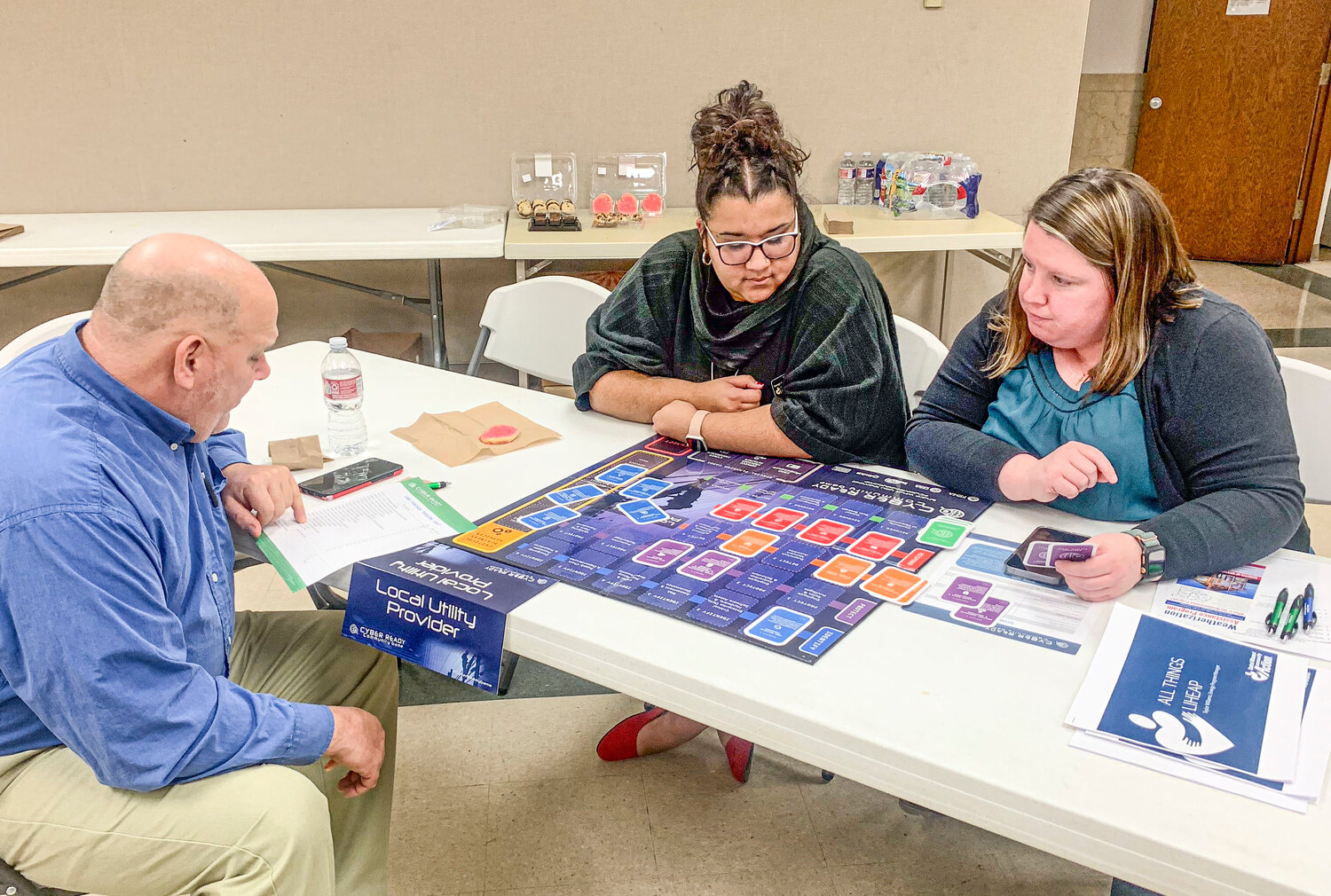 From left, Tad Dobyns and Taylor Williams with Central Missouri Community Action and Audrain County Collector Amy LeCount were in a group together playing a cyber security game. The game was set up by Audrain County Emergency Management Director Carl Donaldson (not pictured).