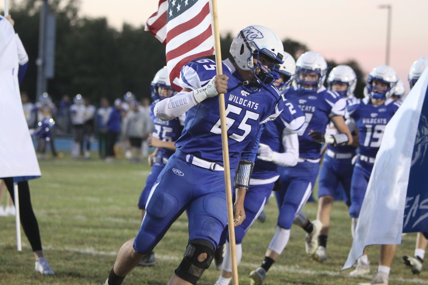 Montgomery County senior Gunner Sexton carries the American flag before a home game against Wright City in September. Sexton is one of nine players the Wildcats will lose to graduation next year.