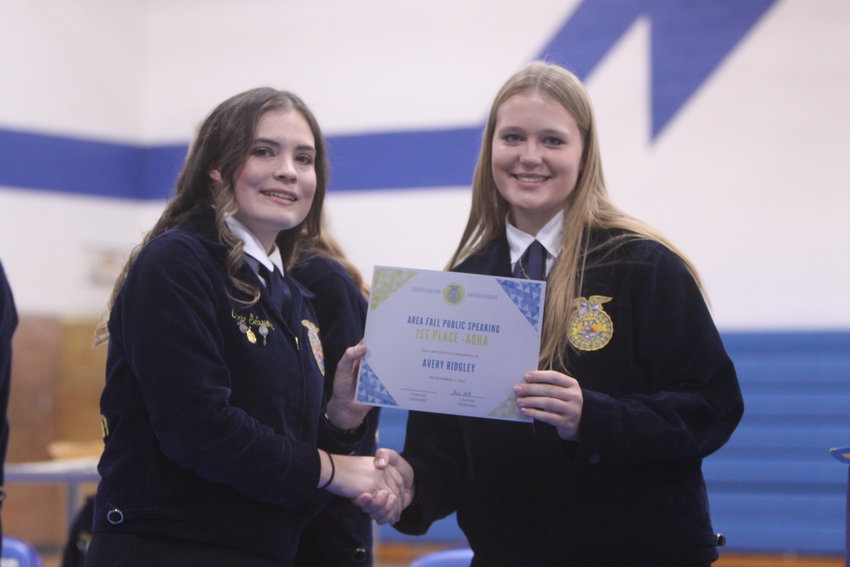 Sophomore Avery Ridgley, right, receives a certificate from senior Carie Schroer for her first-place finish in area speaking competition at the Montgomery County FFA Winter Awards Ceremony on Nov. 16.
