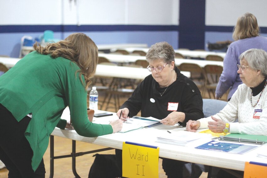 Carol Mills helps a voter sign for registration at the Knights of Columbus Hall in Montgomery City on April 2.