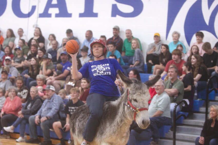 Roxanne Sellenriek attempts to make a shot while riding a donkey during the R-II Donkey Basketball Fundraiser on April 7 at Ballew & Snell Court.