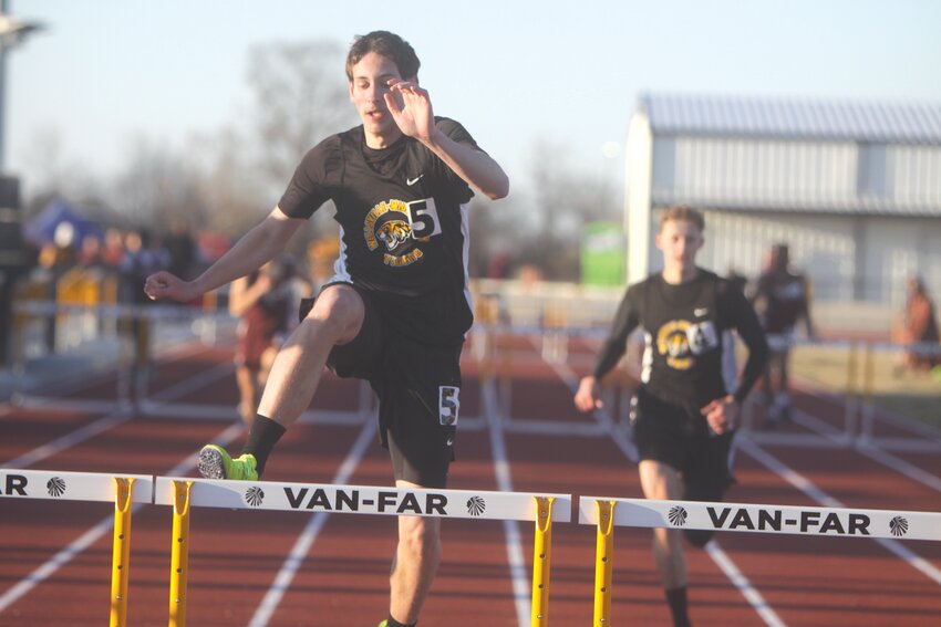 Wellsville-Middletown junior Cooper Henderson clears a hurdle while competing in the 300-meter hurdles at a meet at Van-Far on March 18. Henderson has seven first-place finishes in the hurdle and jumping events this season.