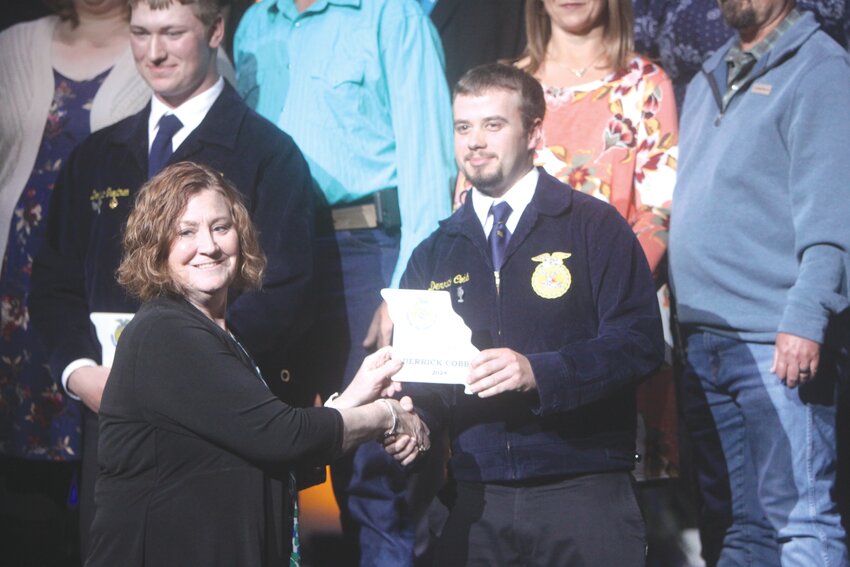 Montgomery County senior Derrick Cobb receives his Area V Star in Placement plaque during the Missouri FFA Convention on April 19 at the Hearnes Center in Columbia.
