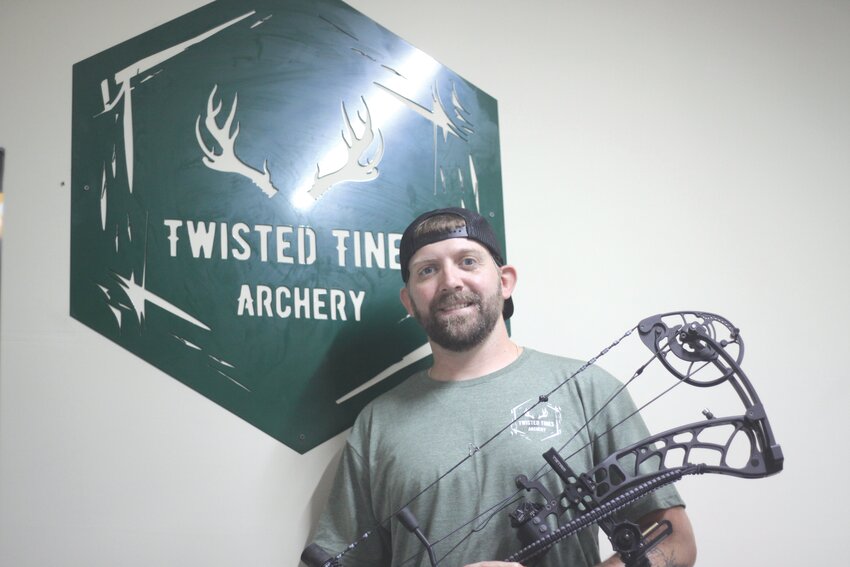 Josh Bickmeyer poses with one of his archery bows at his new business, Twisted Tines Archery, at 1047 Ravenwood Drive in Montgomery City on July 8.
