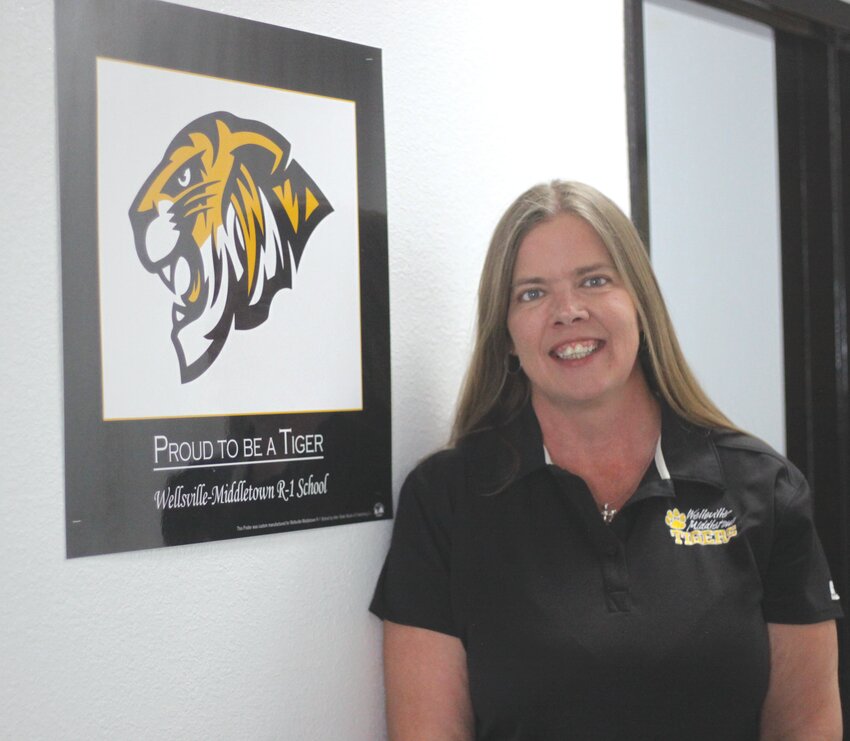 Tiffany Gosseen poses next to the Wellsville-Middletown Tiger logo in the hallway of the elementary school on July 11. Gosseen was hired to take over superintendent duties for the W-M School District for the 2024-25 school year on July 1.