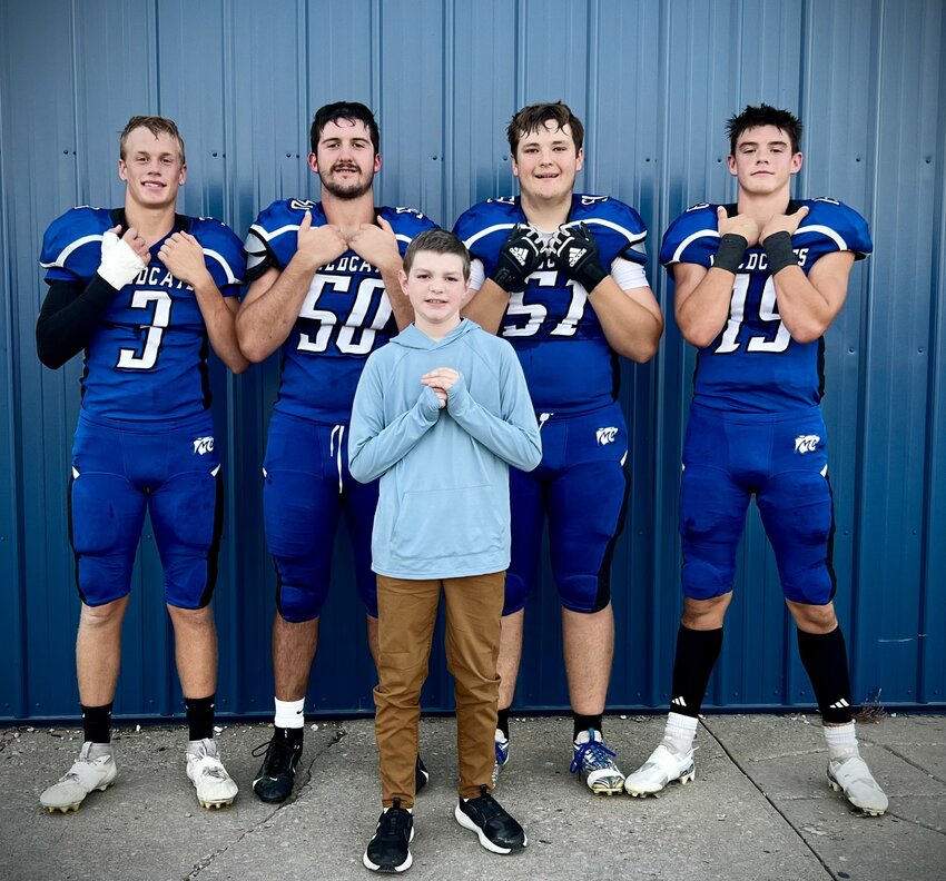 Wellsville resident Avery Penn poses with Montgomery County football captains Chase Queathem, Tatum Wessel, Colby Ellis and Jacob Hogue. Avery, who is 11, will be honored at this year’s MCHS Hero Night Under the Lights event during the Wildcats’ football game against Wright City on Oct. 18.