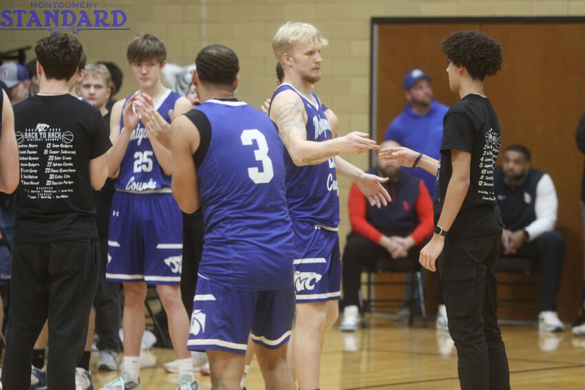 The Montgomery County boys basketball team poses with its district championship plaque after beating Hermann 58-41 in the Class 3, District 7 championship game on Friday at South Callaway High School.