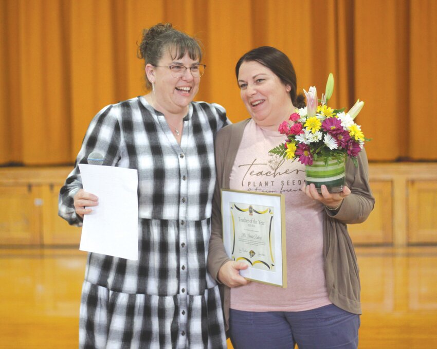 Denise Rakers, right, poses with her Wellsville-Middletown R-I Teacher of the Year award on April 2. On the left is W-M Junior High English teacher Niki Freie.