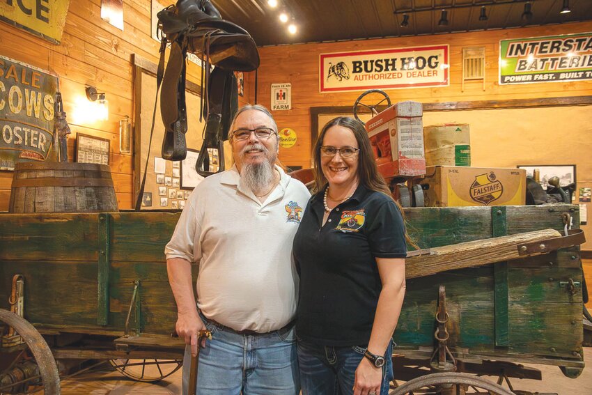 Ted and Brandy Wieberg stand in front of the old wagon, one of their favorite pieces in their restaurant.