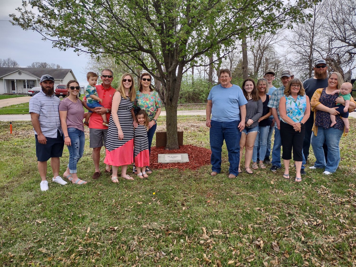 Family members of Jackie Carter pose next to a tree during a memorial tree planting ceremony at the Old Settlers Picnic Grounds on April 23. Carter, who died in 2019, was honored at the ceremony.