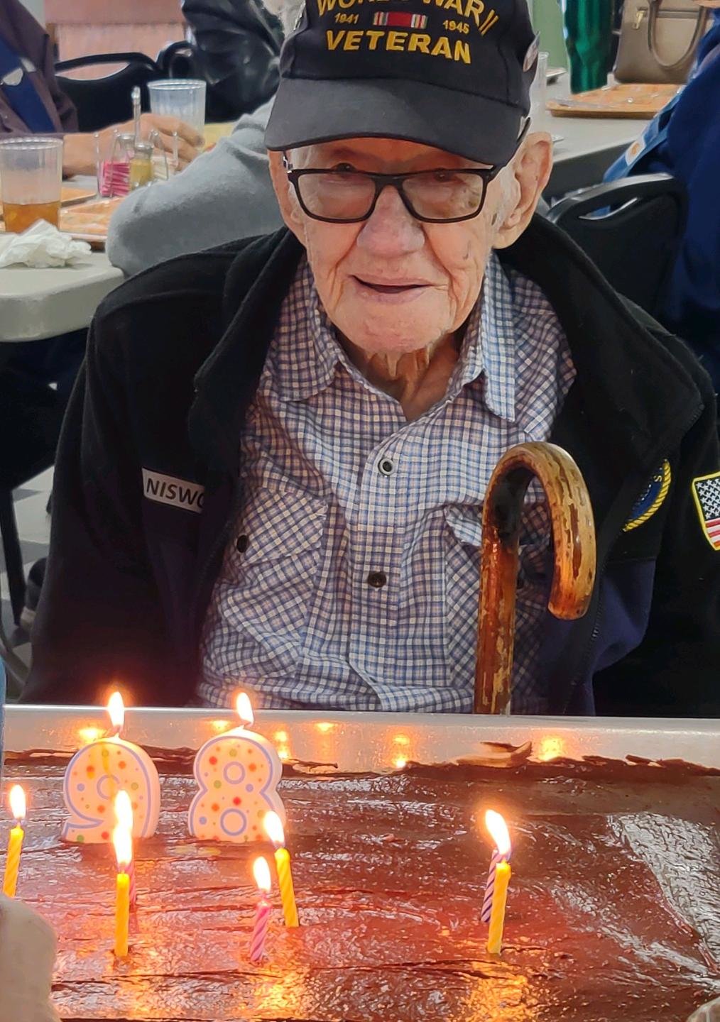Wellsville resident Earl Niswonger attempts to blow out the candles on his birthday cake during his 98th birthday celebration on April 19 at the Montgomery County Senior Center.