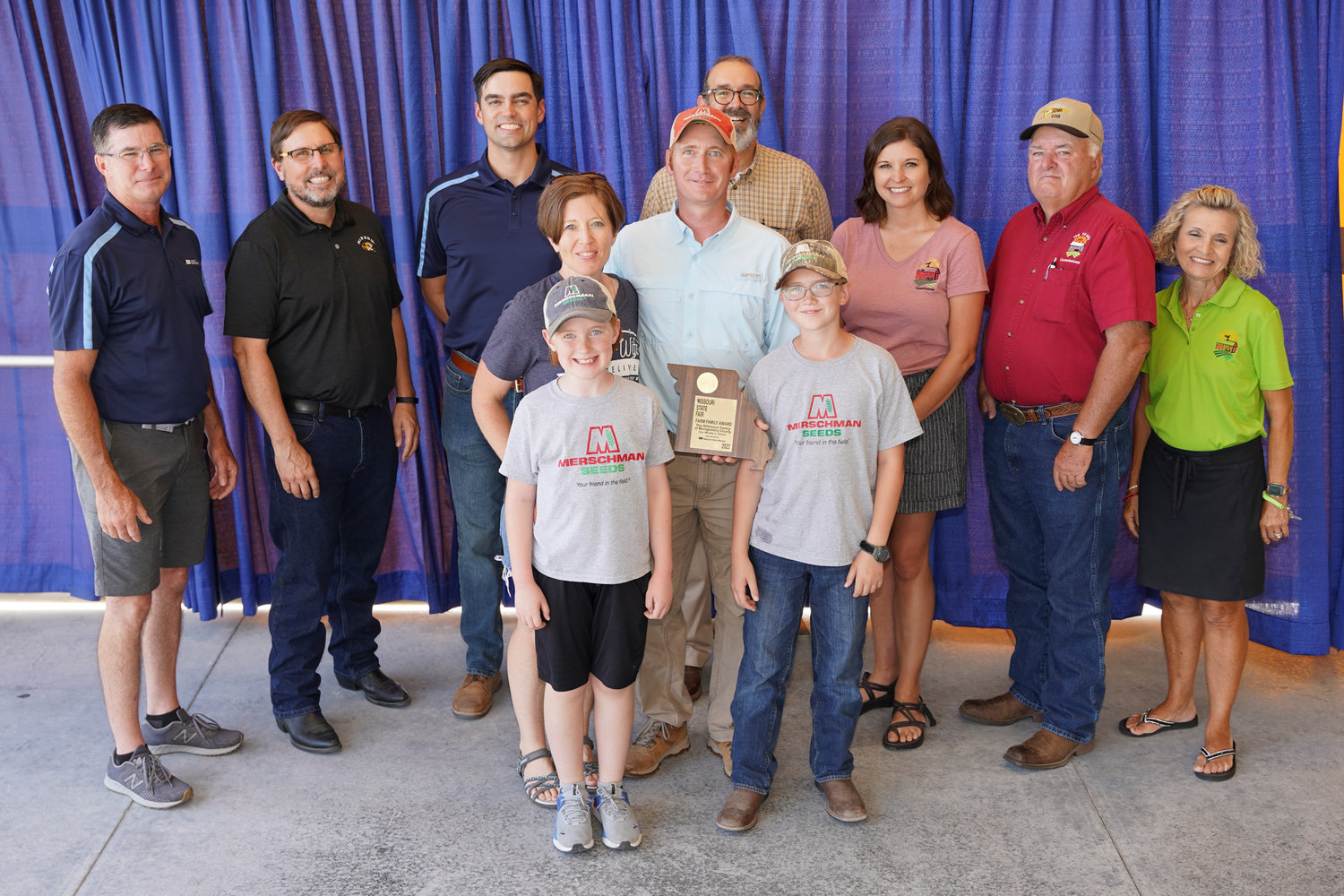 Bill and Andrea Wilkinson and their family were honored during the 64th annual Missouri Farm Family Day on Aug. 15 at the Missouri State Fair. Pictured, front row from left, Liam and Royce Wilkinson. Second row are Andrea and Bill Wilkinson. Back row are Todd Hayes, Missouri Farm Bureau; Rob Kallenbach; Missouri State Fair Commissioner Byron Roach; Blake Rollins, Missouri Farm Bureau; Chad Higgins; Missouri State Fair Commissioner Jamie Johansen; Missouri State Fair Commissioner Ted Sheppard; and Missouri State Fair Commissioner Sherry Jones.