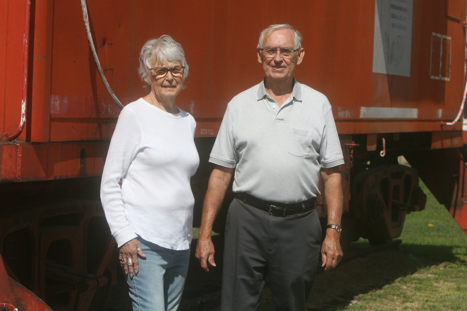 Wellsville residents Paula Adams and Curtis Peery pose near the caboose at the Burlington-Northern Railroad train depot in Wellsville on Sept. 11. Adams and Peery have made plans on improving the depot, which is located on the corner of Hudson and Clay streets.