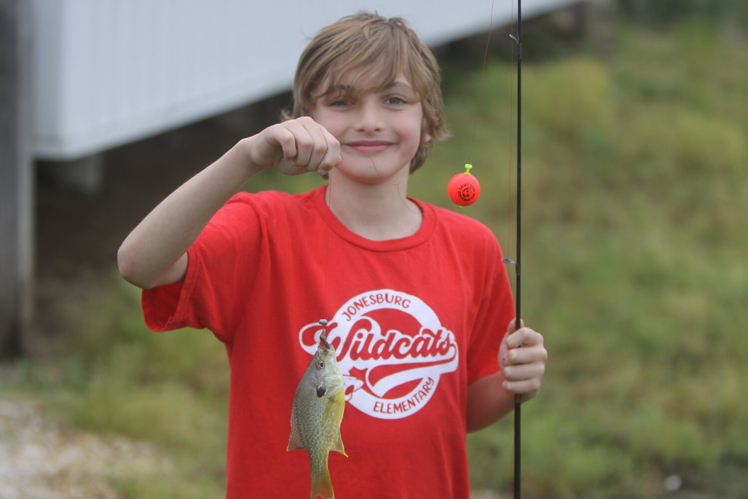 Dylan Finke of Jonesburg Elementary poses with his fish he caught at the Stevens Farm Tour on May 16.