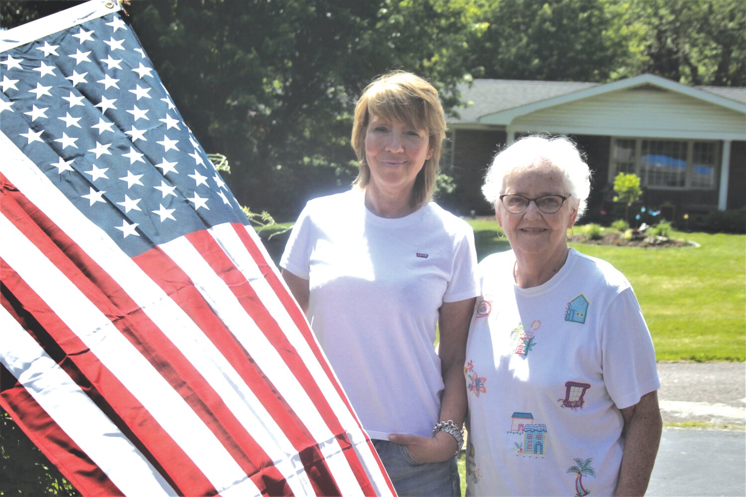 Susanne Enders, left, poses with cousin Barbara Messinger and the American flag on May 22 at Messinger’s residence in High Hill. Enders, who is from Germany, made her first visit to the United States.