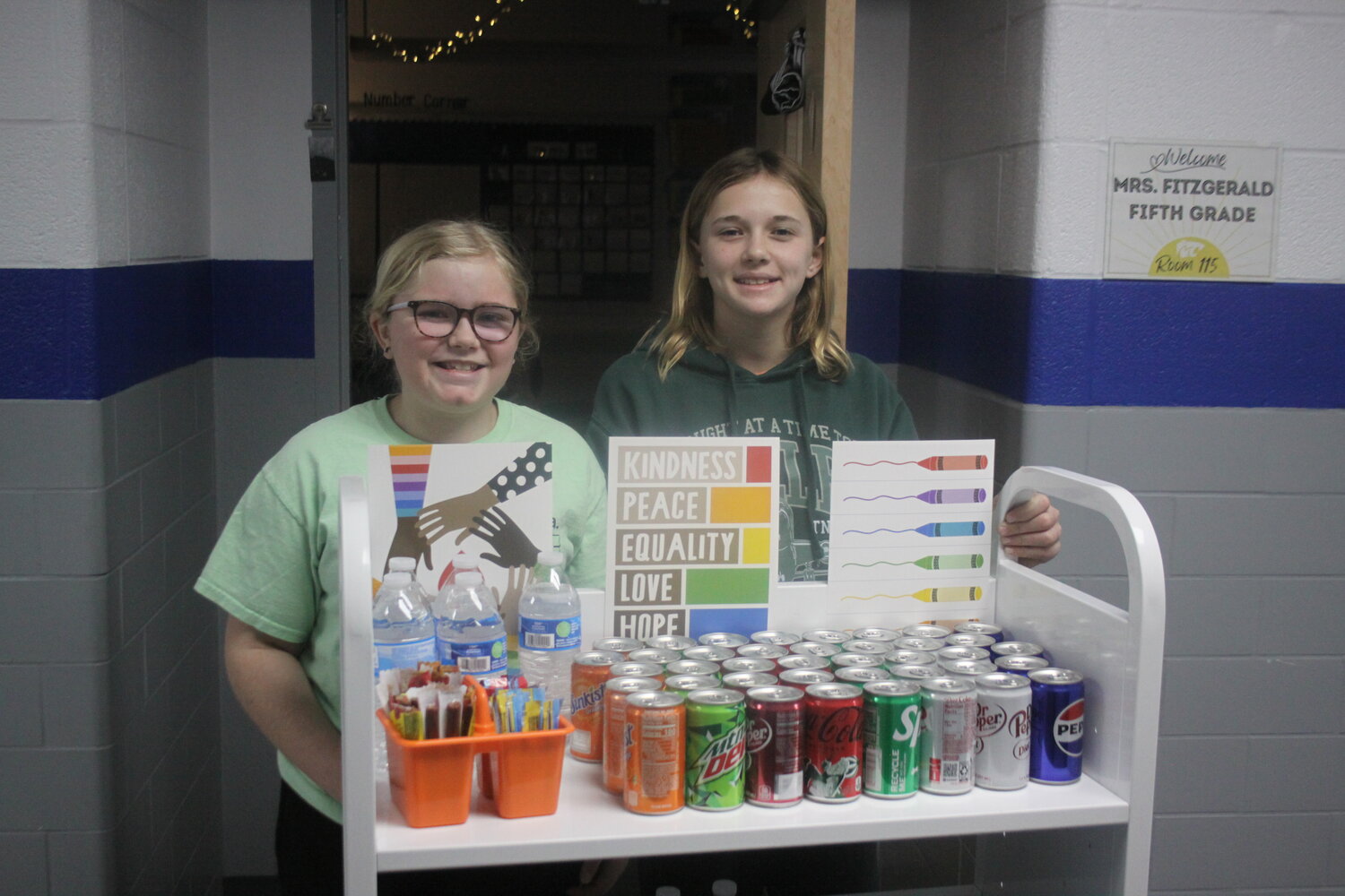 Jonesburg Elementary fifth-grader students Emelia Hans and Ada Boylan pose with their kindness cart on Jan. 26.