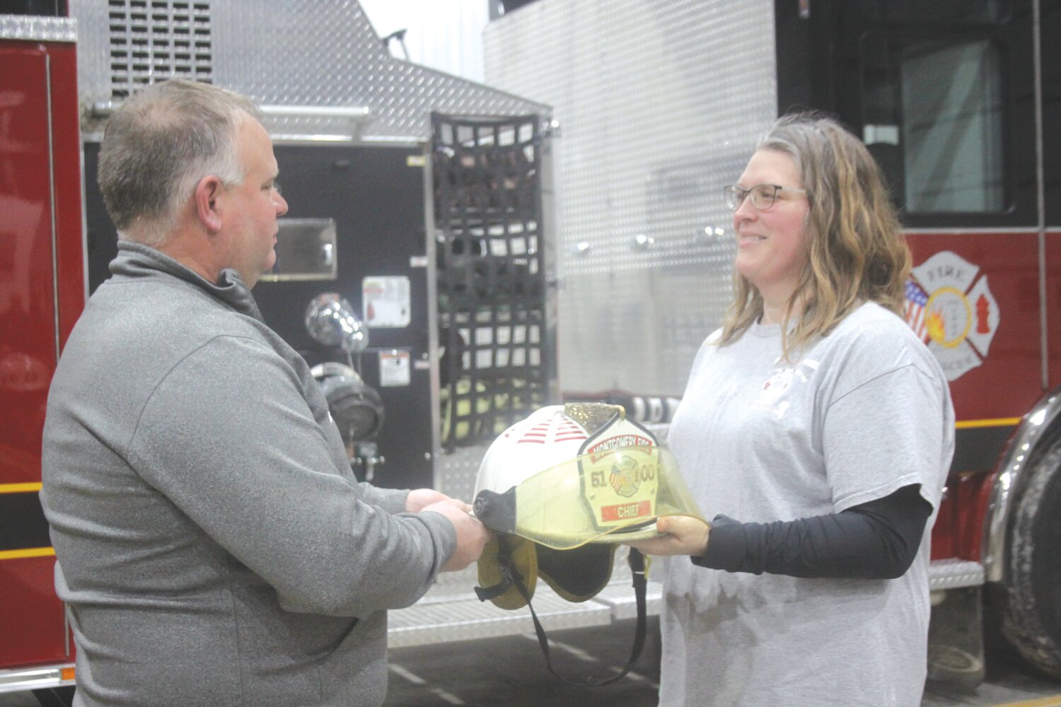 Keith Reynolds hands over the fire chief hat to Jessica Davis during an installation ceremony on Jan. 27 at the Montgomery Fire Protection District building. Davis takes over fire chief duties for Reynolds, who is retiring after 15 years.