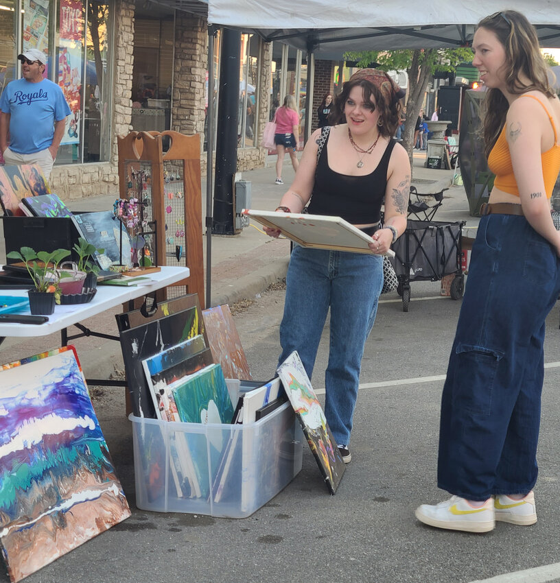 Cassandra Sabatini, left, picks out a painting with Katelynn McCoy at Sparks Joy by Melissa Scanlan’s booth on Saturday. Art styles ranged from pottery to paintings to jewelry at the Pittsburg ArtWalk.