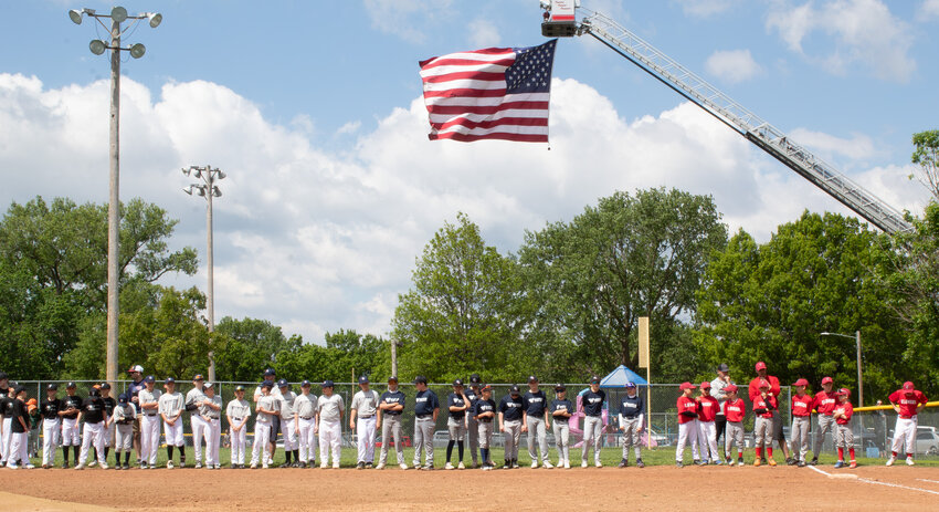 The JL Hutchinson League teams line the field at the start of the opening ceremonies on Saturday, May 3.