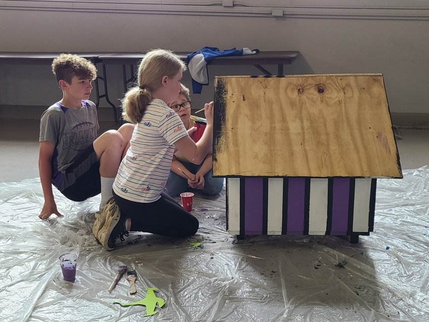 From left, Deklan Harlen, Laci Ingerson, and Dominic Babbles, 5th grade students at Lakeside Elementary, put the finishing touches on the doghouse they made for the SEK Humane Society doghouse auction.