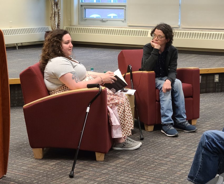 Poet Joshua Davis, right, listens intently as poet Allison Blevins tells the story behind one of her latest poems at the Distinguished Visiting Writers Series at Pittsburg State University on Thursday evening.