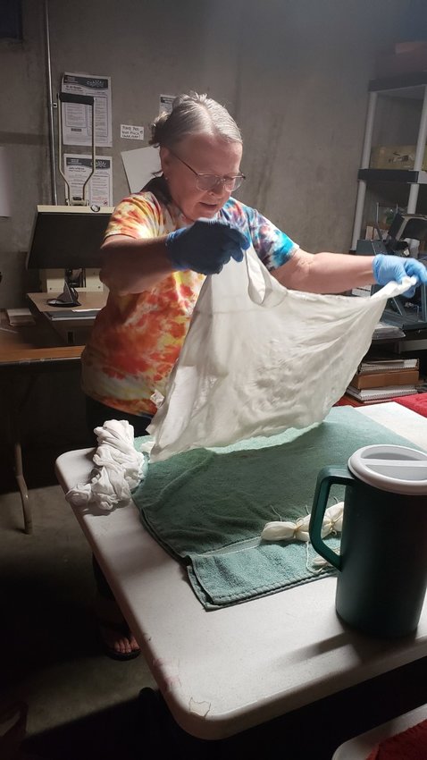 Sue Horner gets ready for the Pittsburg ArtWalk by preparing a T-shirt for tie-dyeing. While her business, Greytwear, makes T-shirts to support greyhound adoption, she also offers her weaving and dyeing for sale at ArtForms in Pittsburg.