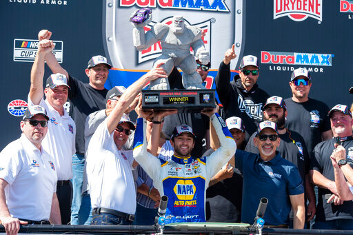 Chase Elliott, center, holds up his trophy after a NASCAR Cup Series auto race at Dover Motor Speedway, Monday, May 2, 2022, in Dover, Del. (AP Photo/Jason Minto)