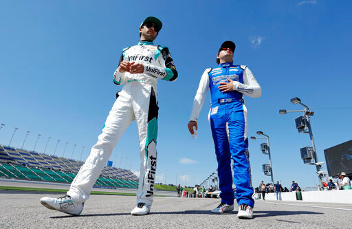 Chase Elliott, left, and Noah Gragson, right, walk to their cars before a practice run for a NASCAR Cup Series auto race at Kansas Speedway in Kansas City, Kan., Saturday, May 14, 2022. (AP Photo/Colin E. Braley)