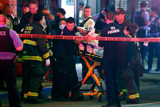 First responders move a shooting victim to an ambulance on Adams Street near State Street in downtown Chicago on Saturday, May 14, 2022. The downtown area saw gun violence and disturbances after a teenage boy was shot and fatally wounded near &ldquo;The Bean&rdquo; sculpture in downtown Chicago's Millennium Park (Terrence Antonio James/Chicago Tribune via AP)