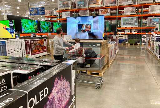 FILE - A shopper pushes a child in a cart while browsing big-screen televisions on display in the electronics section of a Costco warehouse, Tuesday, March 29, 2022, in Lone Tree, Colo.  U.S. retail sales rose 0.9% in April, a solid increase that underscores Americans&rsquo; ability to keep ramping up spending even as inflation persists at nearly a 40-year high. The Commerce Department said Tuesday, May 17,  that the increase was driven by greater sales of cars, electronics, and at restaurants. Even adjusting for inflation, which was 0.3% on a monthly basis in April, sales increased.  (AP Photo/David Zalubowski, File)