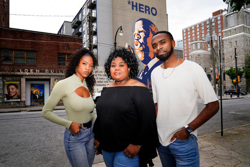 D'Zhane Parker, left, Cicley Gay, center, and Shalomyah Bowers pose for a portrait on Friday, May 13, 2022, in Atlanta. (AP Photo/Brynn Anderson)