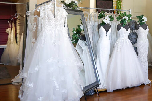 FILE - Wedding dresses are displayed at a bridal shop in East Dundee, Ill., on Feb. 28, 2020. Far fewer Americans were married during the first year of the COVID-19 pandemic, with the number of U.S. marriages in 2020 being the lowest recorded since 1963, according to statistics released by the Centers for Disease Control and Prevention on Tuesday, May 17, 2022. (AP Photo/Teresa Crawford, File)