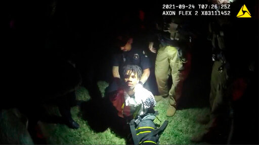 In this image from body camera video provided by Sedgwick County, police put Cedric &ldquo;C.J.&rdquo; Lofton, 17, into a body-length restraining device called a WRAP outside his home in Wichita, Kan., on Sept. 24, 2021. His foster father, unable to deal with a teen who seemed to be in the throes of schizophrenia, had called Wichita police. When they arrived, Cedric refused to leave the porch and go with them; he was obstinate but afraid, meek but frantic. (Sedgwick County via AP)