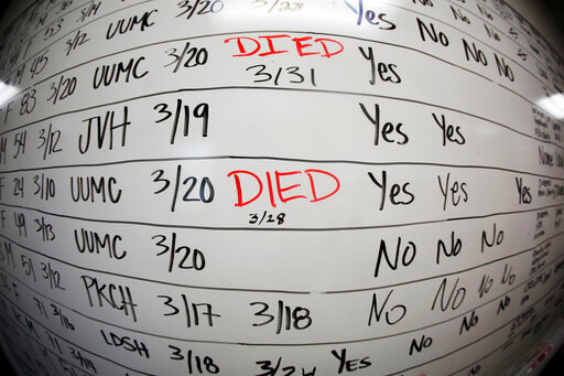FILE - This May 13, 2020 photo made with a fisheye lens shows a list of the confirmed COVID-19 cases in Salt Lake County early in the coronavirus pandemic at the Salt Lake County Health Department, in Salt Lake City. Health officials later moved to tracking the cases in an online database, but the white board remains in the office as a reminder of how quickly the coronavirus spread. (AP Photo/Rick Bowmer)