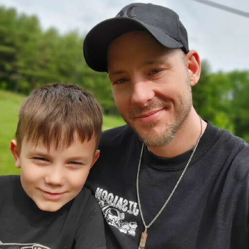 This 2021 photo provided by Billy Price shows him and his son, Maddox in Ohio. Price was already struggling to make ends meet before someone broke into his Michigan storage unit, stole his identity and ruined his credit. He filed a police report, and then tweeted about it to Bill Pulte, a multimillionaire who he'd heard uses Twitter to give money to those in need. (Billy Price via AP)