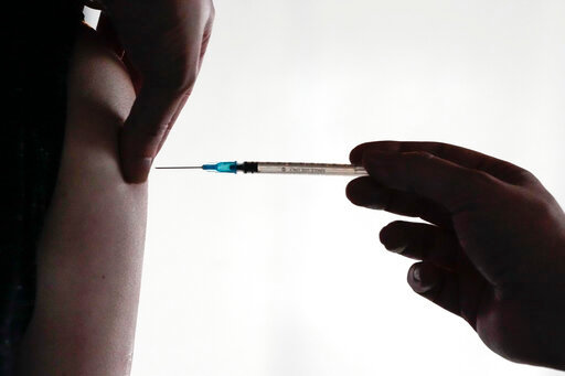 FILE - A doctor injects vaccination against the coronavirus and the COVID-19 disease to a man in Berlin, Germany, Wednesday, Jan. 5, 2022. Germany&rsquo;s top court has approved rules requiring that health workers be vaccinated against COVID-19. The Constitutional Court announced Thursday that it has rejected a complaint against the measure, arguing that protecting vulnerable people in hospitals and care homes is more important than the infringement of health workers' rights. (AP Photo/Markus Schreiber, File)