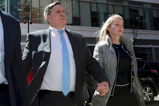 FILE - John Wilson arrives at federal court, with his wife Leslie, on April 3, 2019 to face charges in a nationwide college admissions bribery scandal in Boston. John Wilson and  Gamal Abdelaziz convicted of buying their kids&rsquo; way into elite universities will stay out of prison while they appeal their cases in the college admissions bribery scheme, a Boston judge ordered Thursday, May 19, 2022. (AP Photo/Charles Krupa, File)