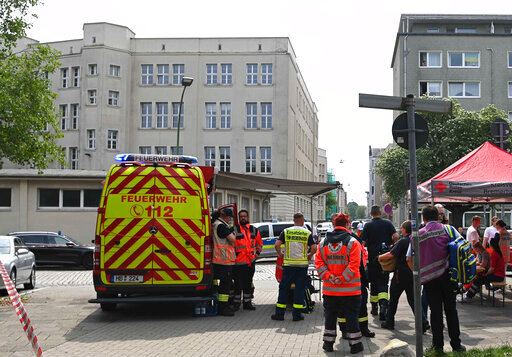 Emergency forces stand near a school in Bremerhaven, Germany, Thursday, May 19, 2022. German police say they have detained a suspect in connection with an attack at a high school in the northern city of Bremerhaven in which one person was injured. Police said the incident happened Thursday morning at the Lloyd high school in the center of the city. (Sina Schuldt/dpa via AP)