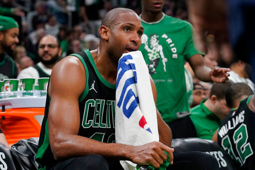 Boston Celtics center Al Horford wipes his face while seated on the bench as the Celtics trail the Milwaukee Bucks in the second half of Game 1 in the second round of the NBA Eastern Conference playoff series, Sunday, May 1, 2022, in Boston. (AP Photo/Steven Senne)