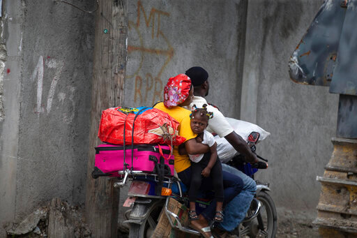 Residents travel on a motorbike as they flee their home to avoid clashes between armed gangs, in the Croix-des-Mission neighborhood of Port-au-Prince, Haiti, Thursday, April 28, 2022. Experts say&nbsp;the scale and duration of gang clashes, the power they are wielding and the amount of territory they control has reached levels not seen before.&nbsp;(AP Photo/Odelyn Joseph)
