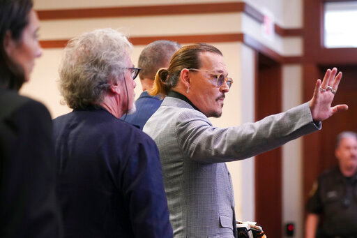 Actor Johnny Depp waves as he leaves the courtroom at the Fairfax County Circuit Courthouse in Fairfax, Va., Thursday, May 19, 2022. Actor Johnny Depp sued his ex-wife Amber Heard for libel in Fairfax County Circuit Court after she wrote an op-ed piece in The Washington Post in 2018 referring to herself as a &quot;public figure representing domestic abuse.&quot; (Shawn Thew/Pool Photo via AP)