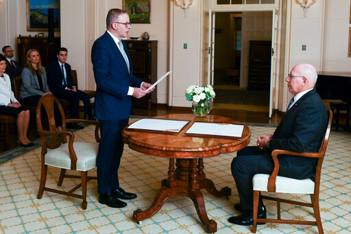 Anthony Albanese is sworn in as Australia's Prime Minister by Australian Governor-General David Hurley, right, during a ceremony at Government House in Canberra, Monday, May 23, 2022. Albanese has been sworn in ahead of a Tokyo summit while vote counting continues to decide whether he will control a majority in a Parliament that is demanding tougher action on climate change. (Lukas Coch/AAP Image via AP)