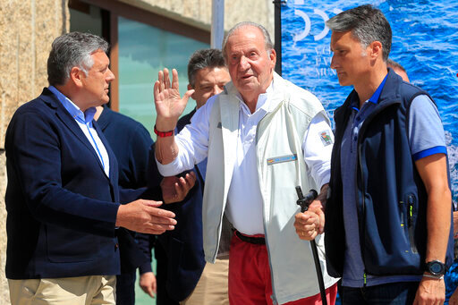 Spain's former King Juan Carlos, centre, waves before a reception at a nautical club prior to a yachting event in Sanxenxo, north western Spain, Friday, May 20, 2022. Spain's former King has returned to Spain for his first visit since leaving nearly two years ago amid a cloud of financial scandals.&nbsp;(AP Photo/Lalo R. Villar)