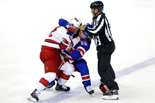 Linesman Jonny Murray tries to stop New York Rangers defenseman Ryan Lindgren (55) and Carolina Hurricanes center Max Domi from fighting after Game 3 of an NHL hockey Stanley Cup second-round playoff series, Sunday, May 22, 2022, in New York. (AP Photo/Adam Hunger)