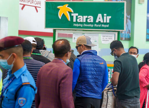 A signage of Tara Airlines is seen behind as a team of climbers prepare to leave for rescue operations from the Tribhuvan International Airport in Kathmandu, Nepal, Sunday, May 29, 2022. A small airplane with 22 people on board flying on a popular tourist route was missing in Nepal&rsquo;s mountains on Sunday, an official said. The Tara Airlines plane, which was on a 15-minute scheduled flight to the mountain town of Jomsom, took off from the resort town of Pokhara, 200 kilometers (125 miles) east of Kathmandu. It lost contact with the airport tower shortly after takeoff. (AP Photo/Niranjan Shreshta)