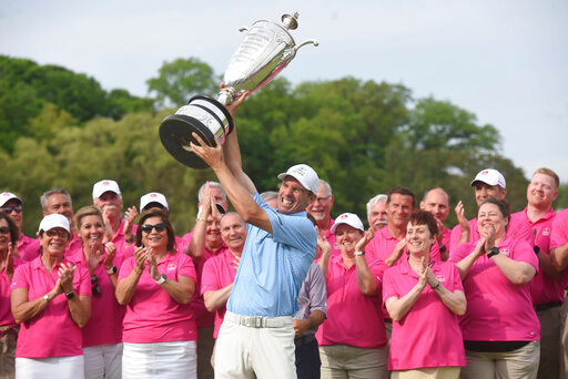 Steven Alker, center, raises the Alfred S. Bourne Trophy, Sunday, May 29, 2022, after winning the Senior PGA Championship golf tournament at Harbor Shores in Benton Harbor, Mich. (Don Campbell/The Herald-Palladium via AP)